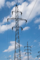 Energy supply. Electricity poles and white clouds.