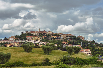 Fototapeta na wymiar View of the hill with houses and the bell tower of the city of Montanio in Tuscany.