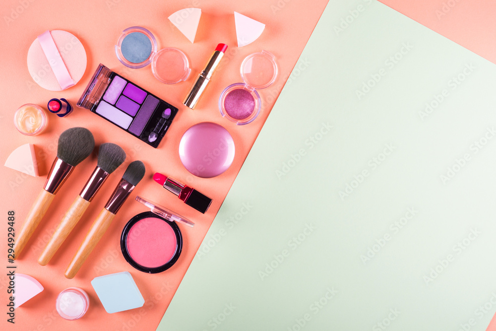 Wall mural Make up accessories on orange cantaloupe and mint green background. Beauty products colorful fashion flat lay