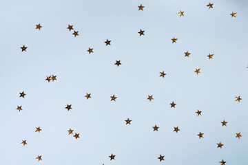 Christmas pattern made of golden stars on blue background. Christmas, Valentines or birthday background. Flat lay.