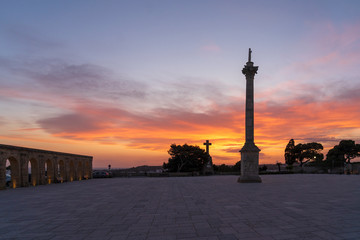 Fototapeta na wymiar Sunset at Santa Maria di Leuca. Santa Maria di Leuca, Colonna Corinzia - Salento, Lecce, Apulia, Italy . Religious symbol, crucifix, cross - Immagine