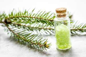 spa with organic spruce sea salt in glass bottles on white table background