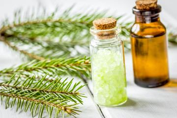 spa with organic spruce oil and sea salt in glass bottles on white table background