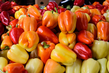 Group of fresh red and yellow peppers, available for sale at a street food market, natural background, soft focus