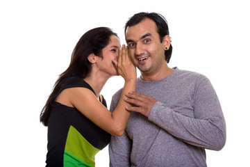 Naklejka premium Happy Persian couple smiling while woman whispering to man