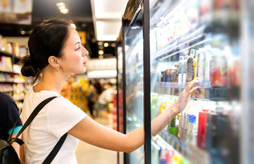Portrait of caucasian woman looking at product at grocery store. Happy hispanic girl shopping in supermarket reading product information. Costumer buying food at the market, woman lifestyle concept.
