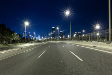 Fototapeta na wymiar Empty Freeway At Night And Tel Aviv Skyline in Background