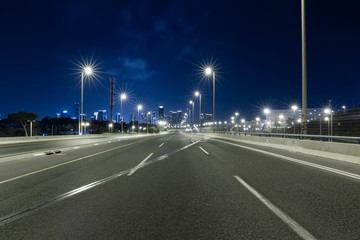 Fototapeta na wymiar Empty Freeway At Night And Tel Aviv Skyline in Background