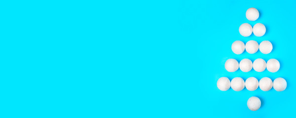 Banner. Silhouette of a Christmas tree made of white New Year's toys on a blue background. Creative decoration.