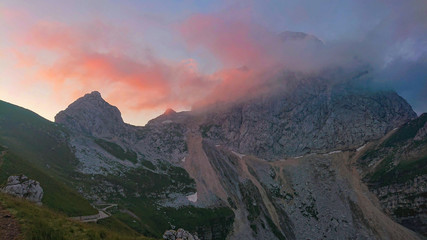 Gentle wind blowing clouds over the summit of a rocky mountain in Julian Alps.