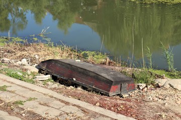 body of water, on the shore lies a boat turned upside down