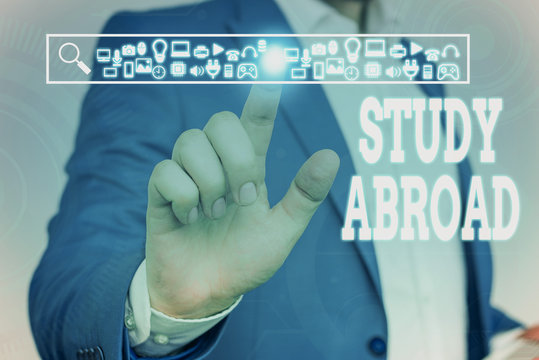 Handwriting text Study Abroad. Conceptual photo live in a foreign country and attend a foreign university Male human wear formal work suit presenting presentation using smart device