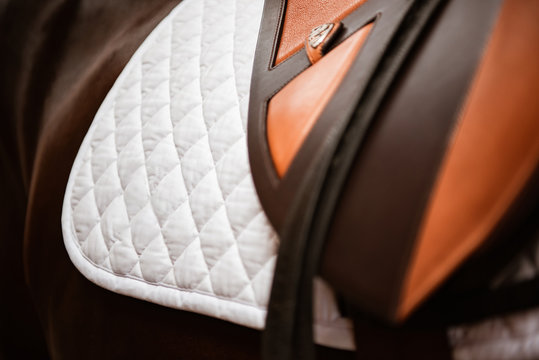 Detail brauner Springsattel auf wei&szlig;er, gesteppter Satteldecke