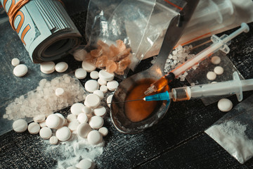 Hard drugs on dark table.Addiction concept. Drug syringe and cooked heroin