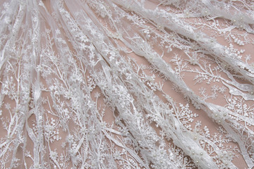 Texture lace fabric. lace on white background studio. thin fabric made of yarn or thread. a background image of ivory-colored lace cloth. White lace on beige background.