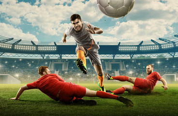 Three soccer players on a professional field fighting for the ball