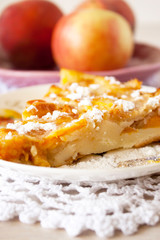 Homemade fruit apple apricot peach pie on white crochet napkin on white rustic table background