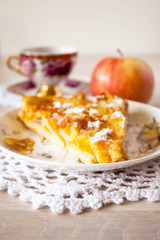 Homemade fruit apple apricot peach pie on white crochet napkin on white rustic table background