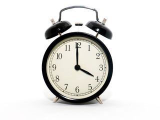 Old-style alarm clock, black and white, it's four o'clock.