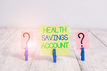 Conceptual hand writing showing Health Savings Account. Concept meaning users with High Deductible Health Insurance Policy Crumbling sheet with paper clips placed on the wooden table