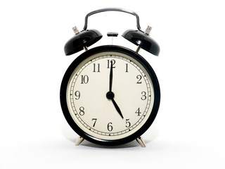 Old-style alarm clock, black and white, it's five o'clock.