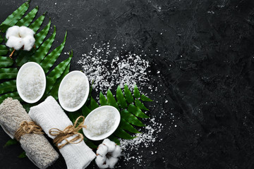 Spa. Sea salt and cosmetic towels. On a black stone background. Top view. Free space for your text.