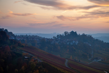 Panoramic view of Stuttgart in autumn. The vineyards' leafs are colorful changing from yellow to red, while the sun is setting above the Neckar valley.
