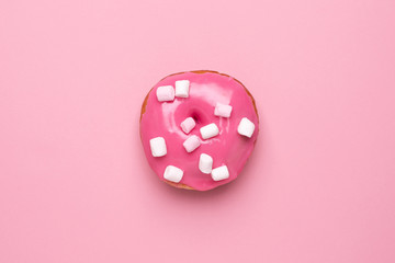 Sweet pink donut with marshmallows on a pink background flat lay