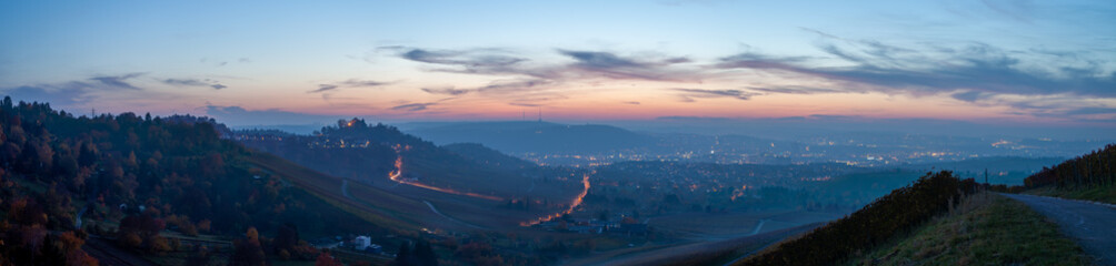 Panoramic view of Stuttgart in autumn. The vineyards' leafs are colorful changing from yellow to red, while the sun is setting above the Neckar valley.