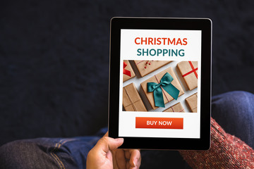 Hands holding tablet with Christmas shopping concept on screen