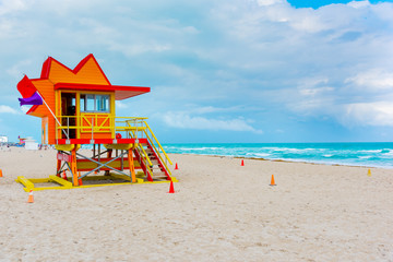 Red and orange lifeguard tower in Miami Beach on a cloudy day