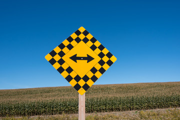 traffic signs in front of large corn field