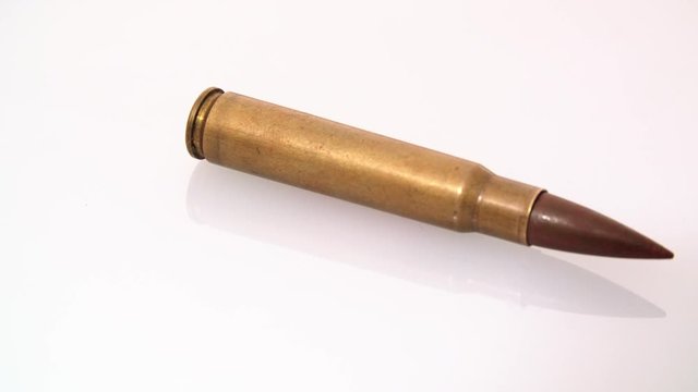 Single .50 Bmg Machine Gun  bullet shell rotating on white background. Ammo Ammunition