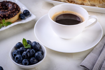 Breakfast with coffee and baking on light background