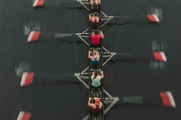 Blurred motion overhead view of a rowing crew in a sculling boat on the water, mid stroke,Lake Union