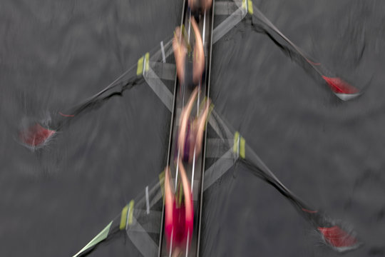 Blurred motion overhead view of a rowing crew in a sculling boat on the water, mid stroke,Lake Union