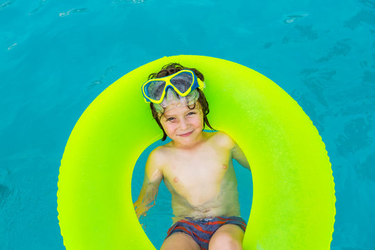 Shirtless boy with swim ring in swimming pool
