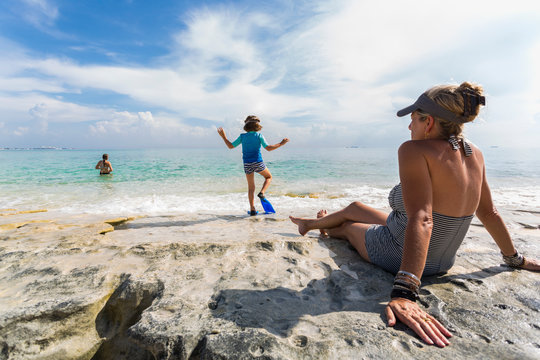 5 year old boy walking on rock formation with fins, Grand Cayman Island