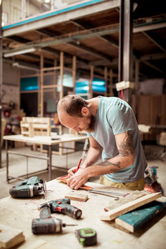 Carpenter working at workbench in workshop