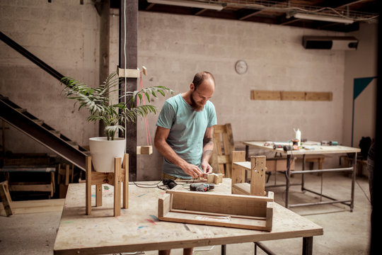 Carpenter making wooden object while working in workshop