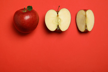 Flat lay composition with ripe juicy apples on red background, space for text