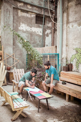 Male carpenters planning while sitting outdoors