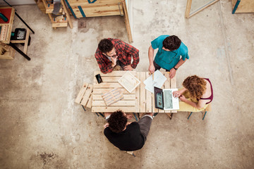 High angle view of carpenters planning while sitting at desk