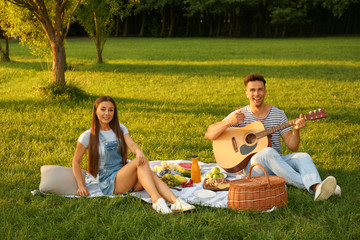 Happy couple having picnic in park on sunny day