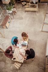 High angle view of carpenters working with laptop at desk in workshop