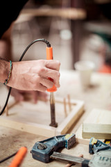 Cropped hands repairing wooden equipment