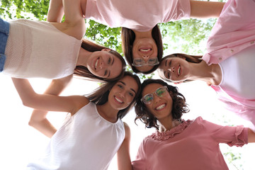 Happy women joined in circle outdoors, bottom view. Girl power concept