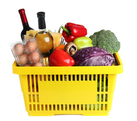 Shopping basket with grocery products on white background
