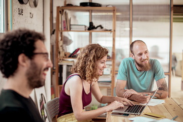 Cheerful colleagues working at desk in office