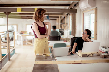 Females colleagues talking at desk in office